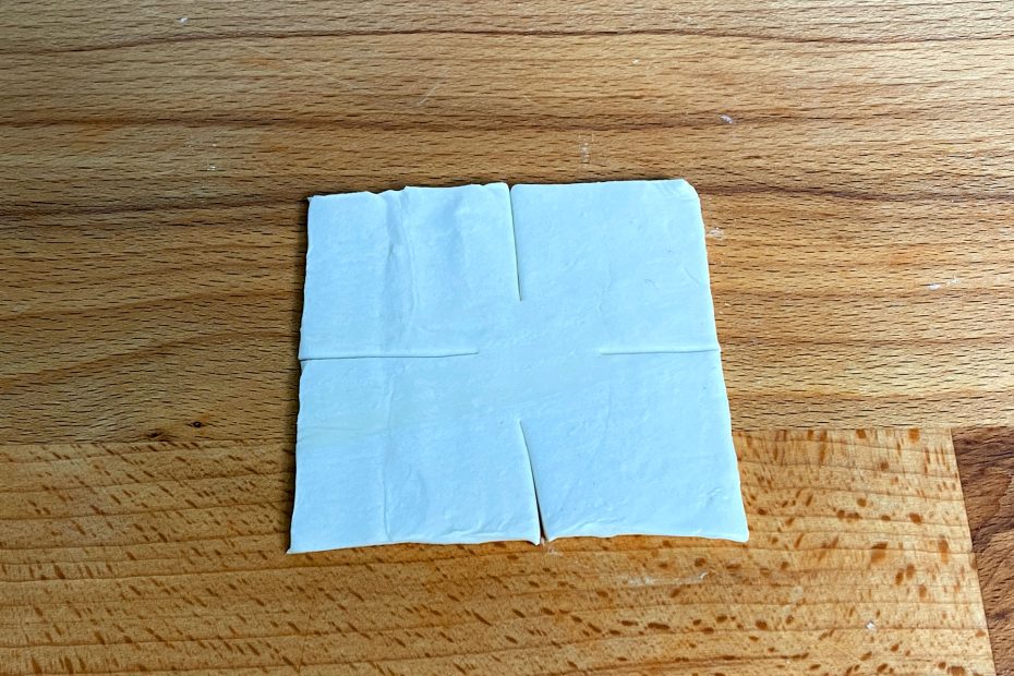 quadratisches Stück Blätterteig mit einschnitten auf allen Seiten zur Mitte hin